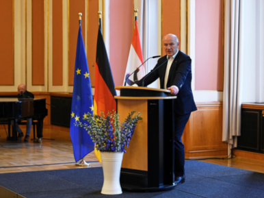 Der Regierende Bürgermeister von Berlin, Kai Wegner, eröffnet die Europass-Verleihung. Links des Rednerpults sind die Flaggen der EU, Deutschlands und Berlins zu sehen