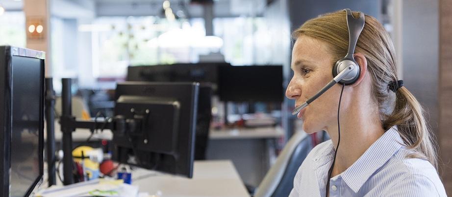 Frau mit Headset am PC