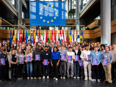 Gruppenbild von Auszubildenden mit Europass Mobilität im EU Parlament im Hintergrund die Flaggen und die EU-Flagge