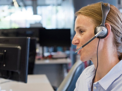 Frau mit Headset am Computer