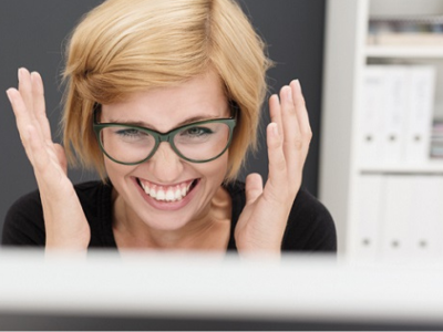 Lachende Frau am Laptop im Büro