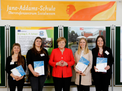 Vier Auszubildende mit Europass Mobilität, in der Mitte Angela Merkel