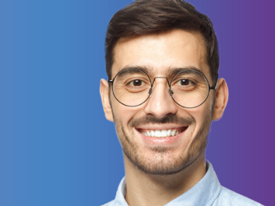 Dunkelhaariger Mann mit Brille, lächelnd vor blau-lila Farbverlauf